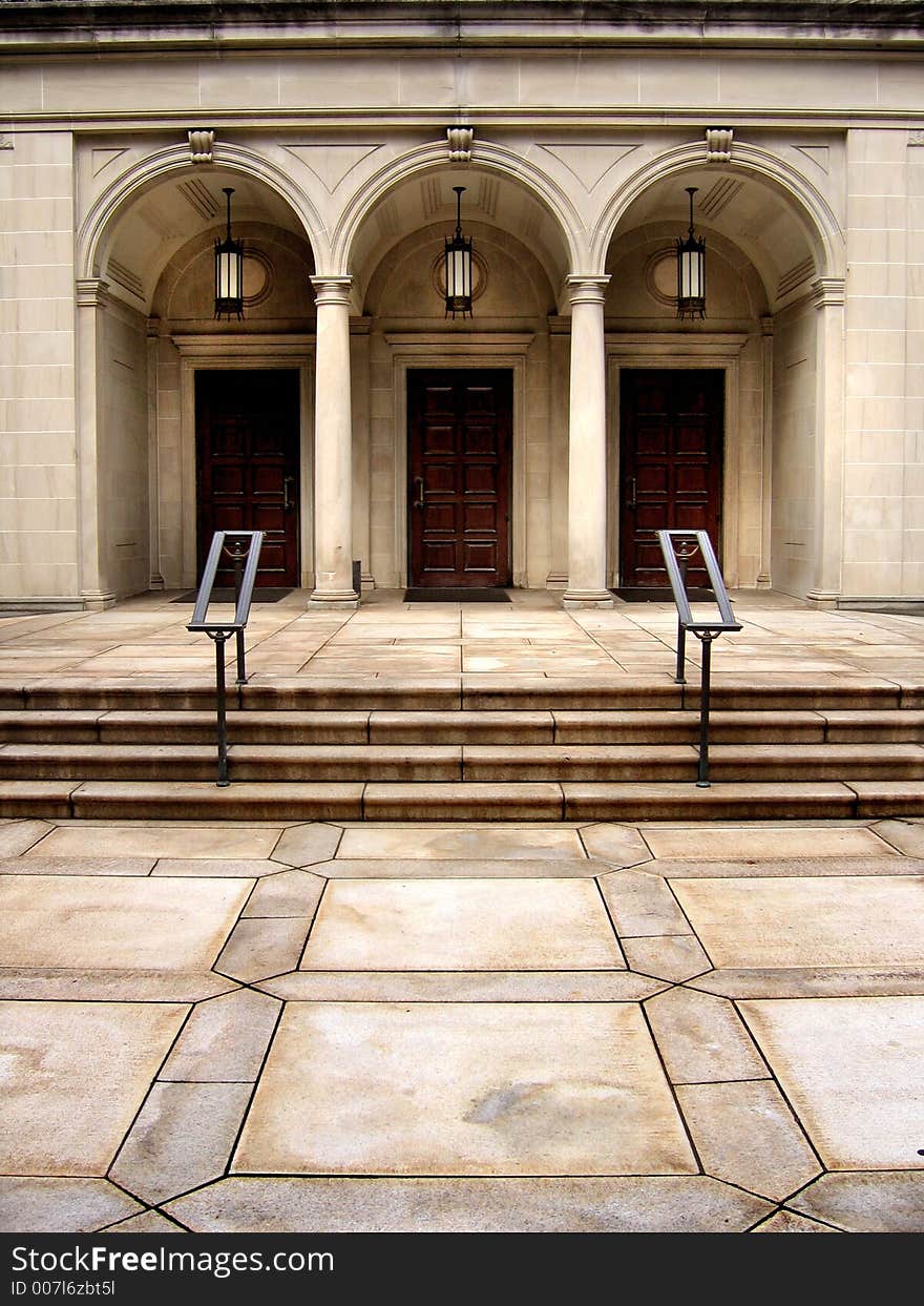 Arched doorways and stairs with lamps and railings.