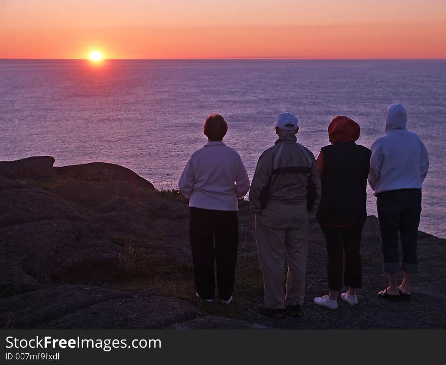 A group of tourists enjoying a coastal sunrise