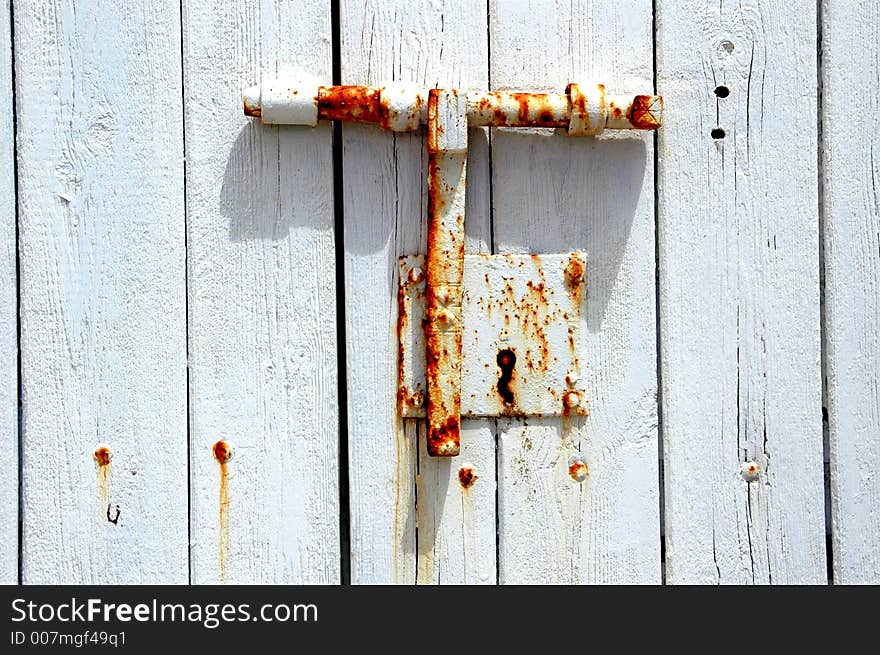 An old and decorative white latch. An old and decorative white latch