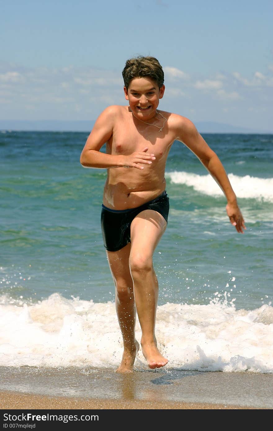 The boy runs from waves. The boy runs from waves