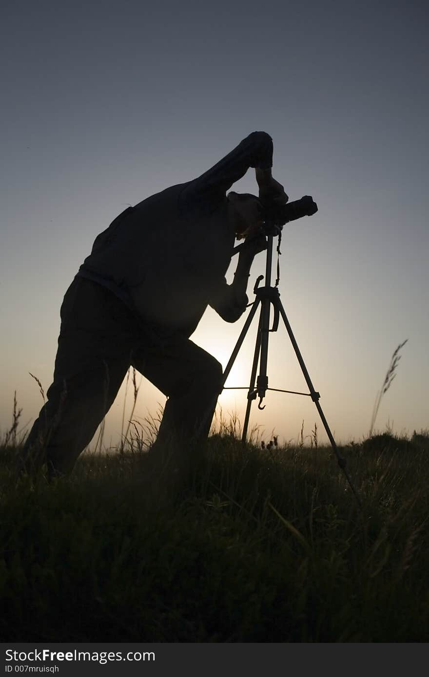 Photographer silhouette in back-light at the sunrise. Photographer silhouette in back-light at the sunrise