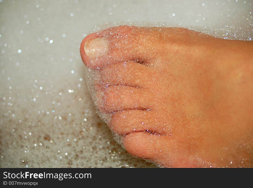 Womens feet in bath with droplets. Womens feet in bath with droplets