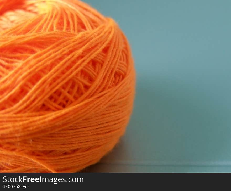 Ball of orange yarn used for sewing.