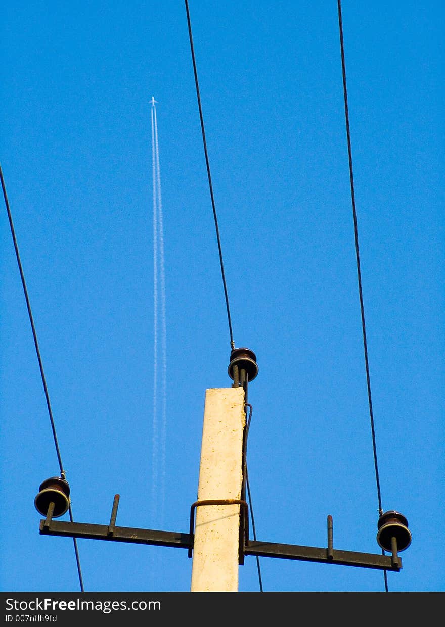 Jet plane trace and electricity pillar with wires