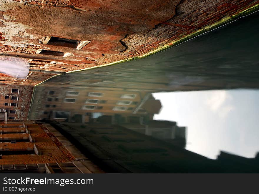 A white sheet flaps in the gentle breeze down a back street canal. A white sheet flaps in the gentle breeze down a back street canal.