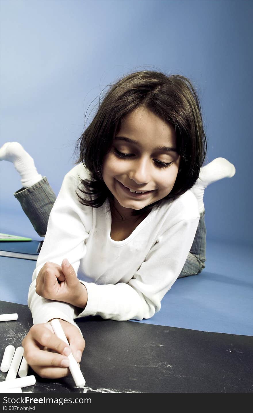 Little girl writing on board on the floor