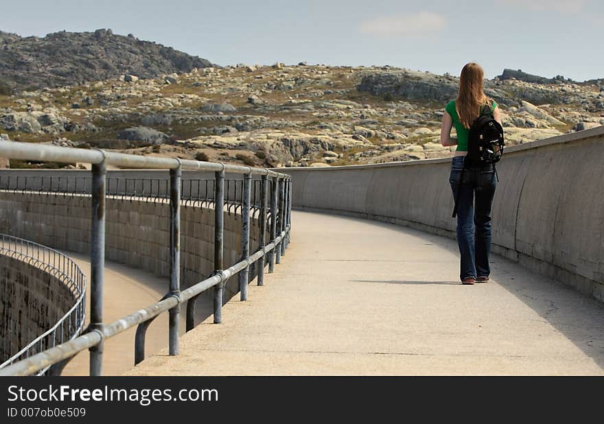 Woman walking on the side of the dam