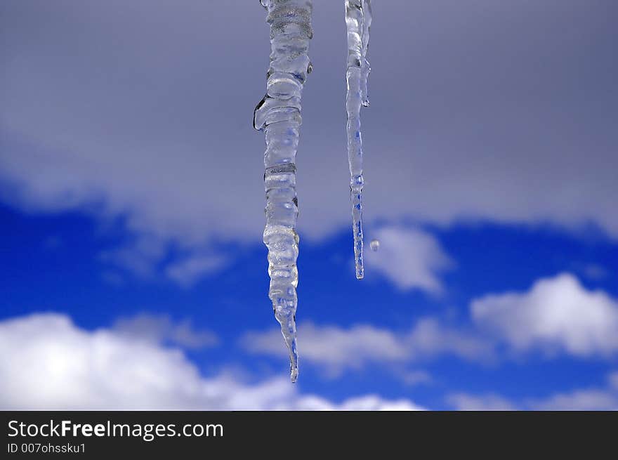 Icicles hanging with blue sky and clouds in the background. Icicles hanging with blue sky and clouds in the background