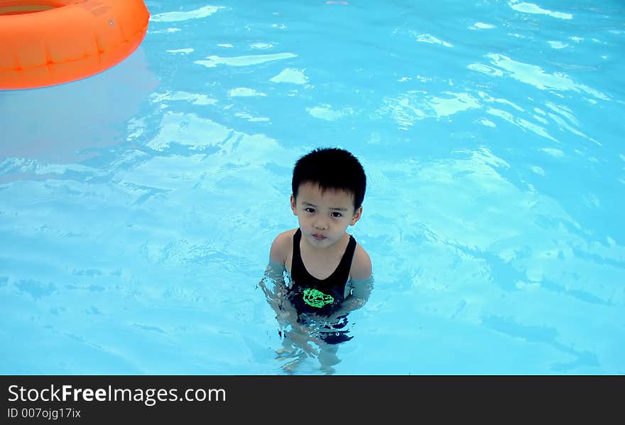 A boy is standing in a pool