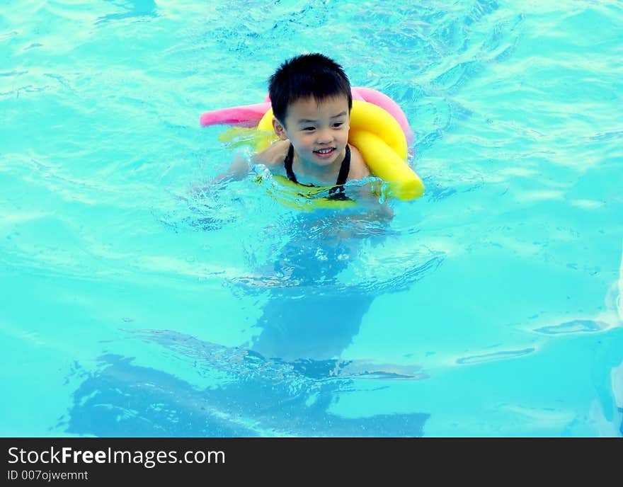 A boy is swimming in a pool