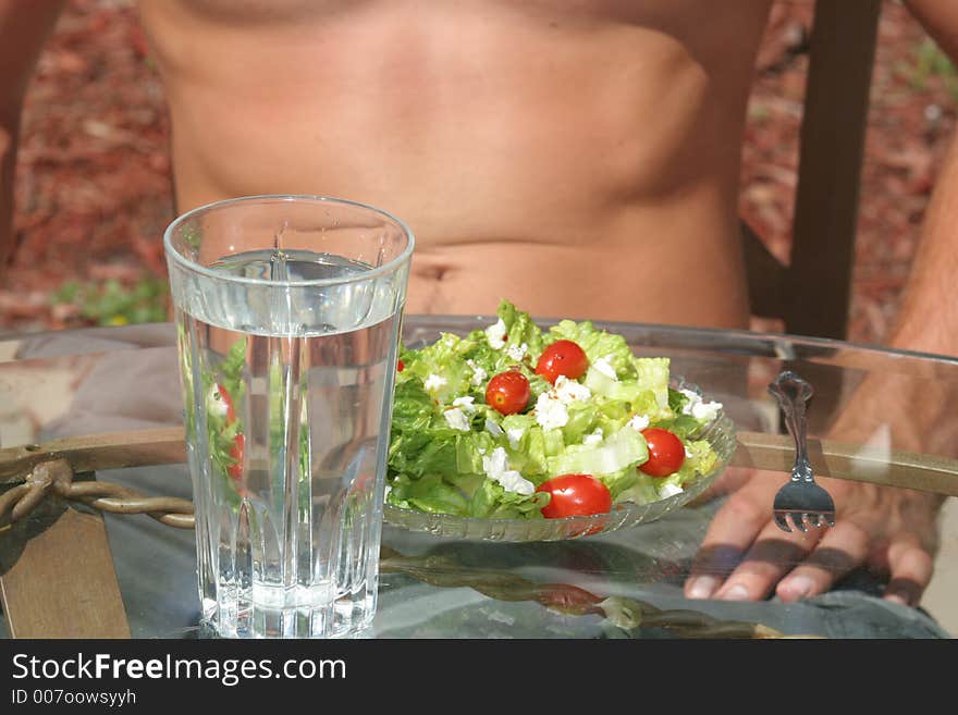 Toned male enjoying a salad. Toned male enjoying a salad