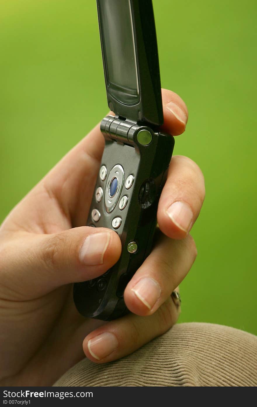 The image of the man's hand pressing on the buttons of the mobile phone. The image of the man's hand pressing on the buttons of the mobile phone