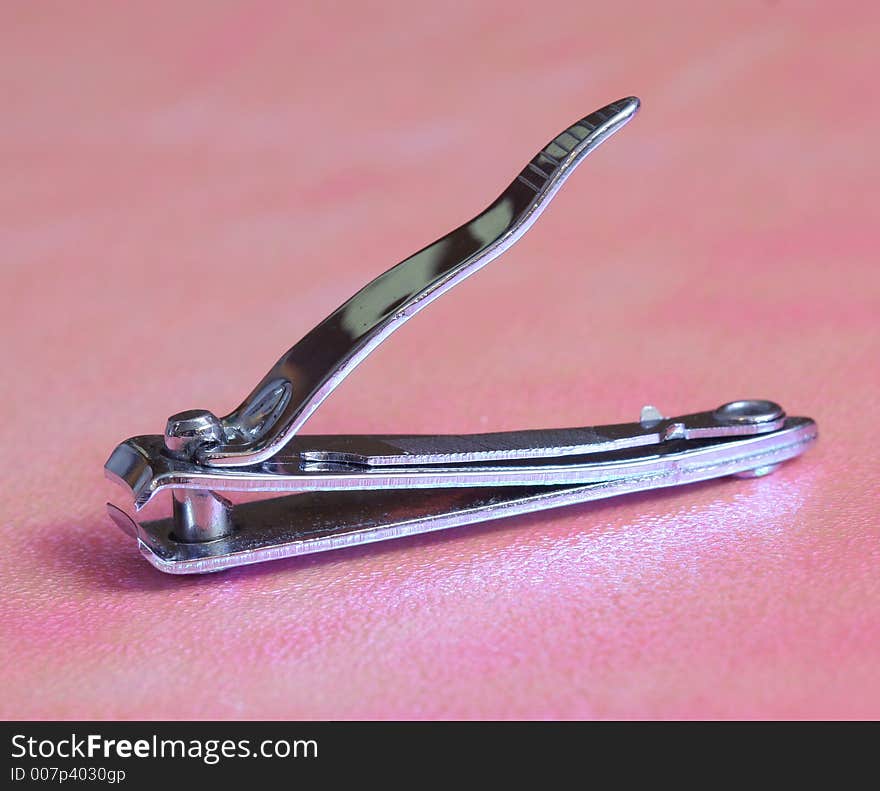 Metal nail cutter in a pink background