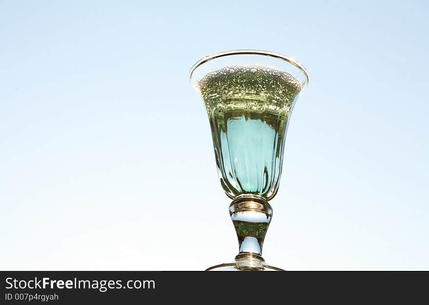 Blue coktail glass with sky in backround