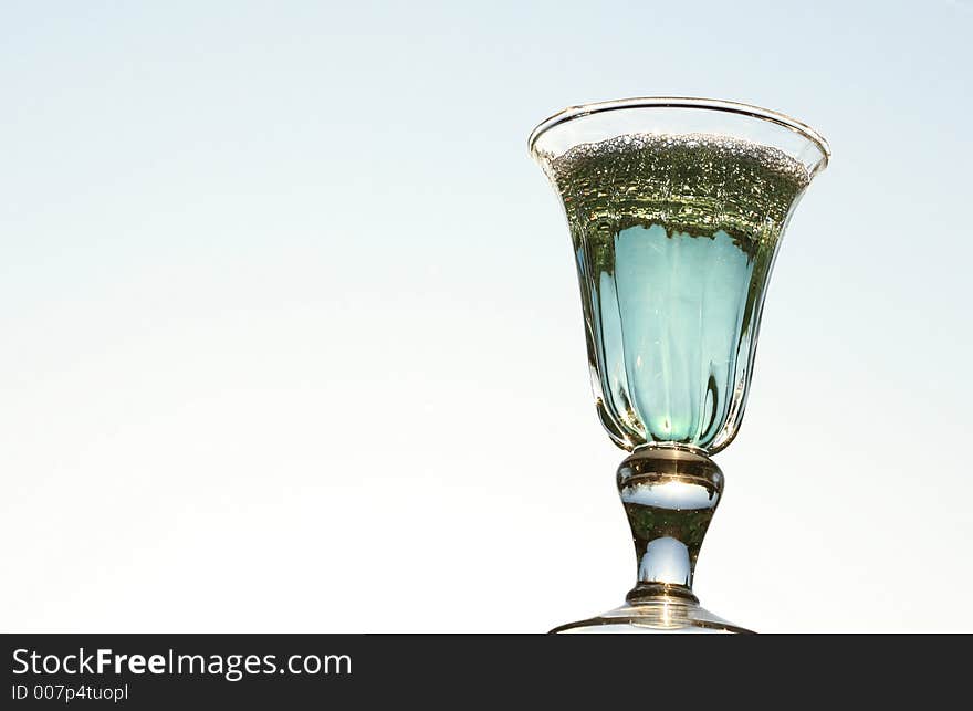 Blue coktail glass with sky in backround