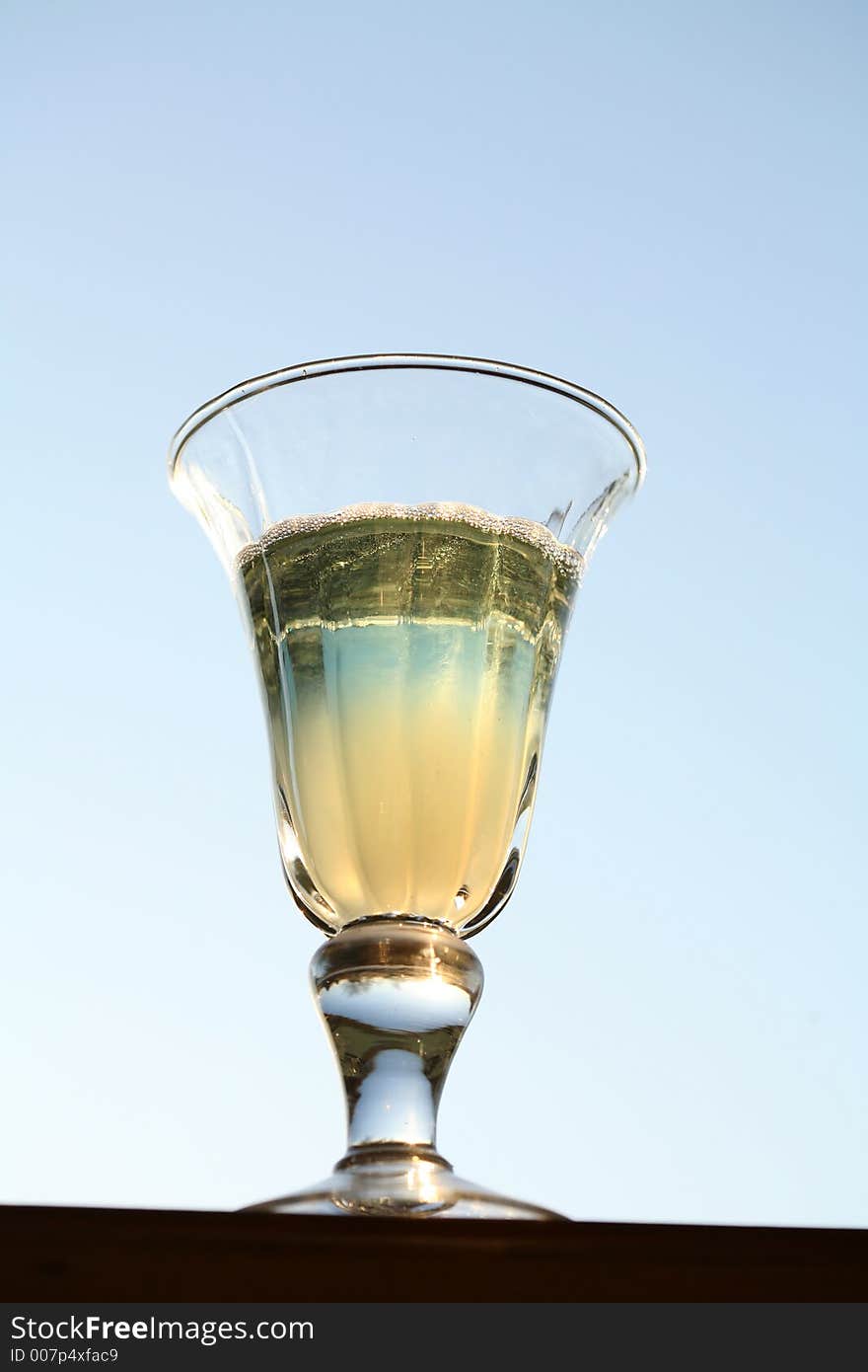 Blue coktail glass with sky in backround