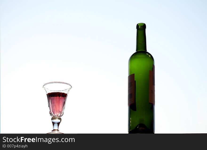 Wine glass and  bottle with light blue background