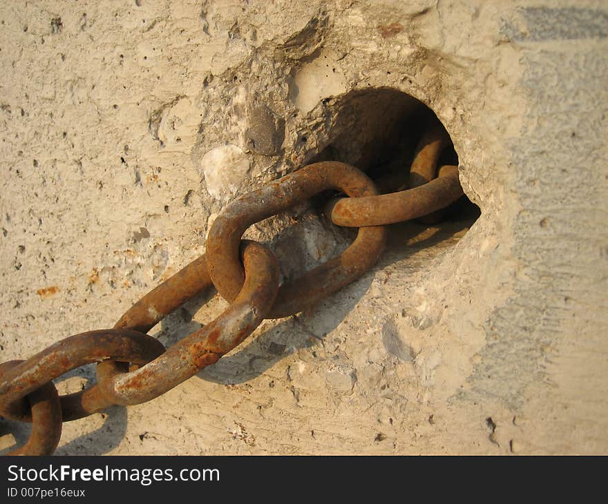 Rusty chain in front of a wall