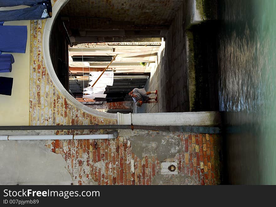 An old woman bends over after hanging out her washing. An old woman bends over after hanging out her washing.