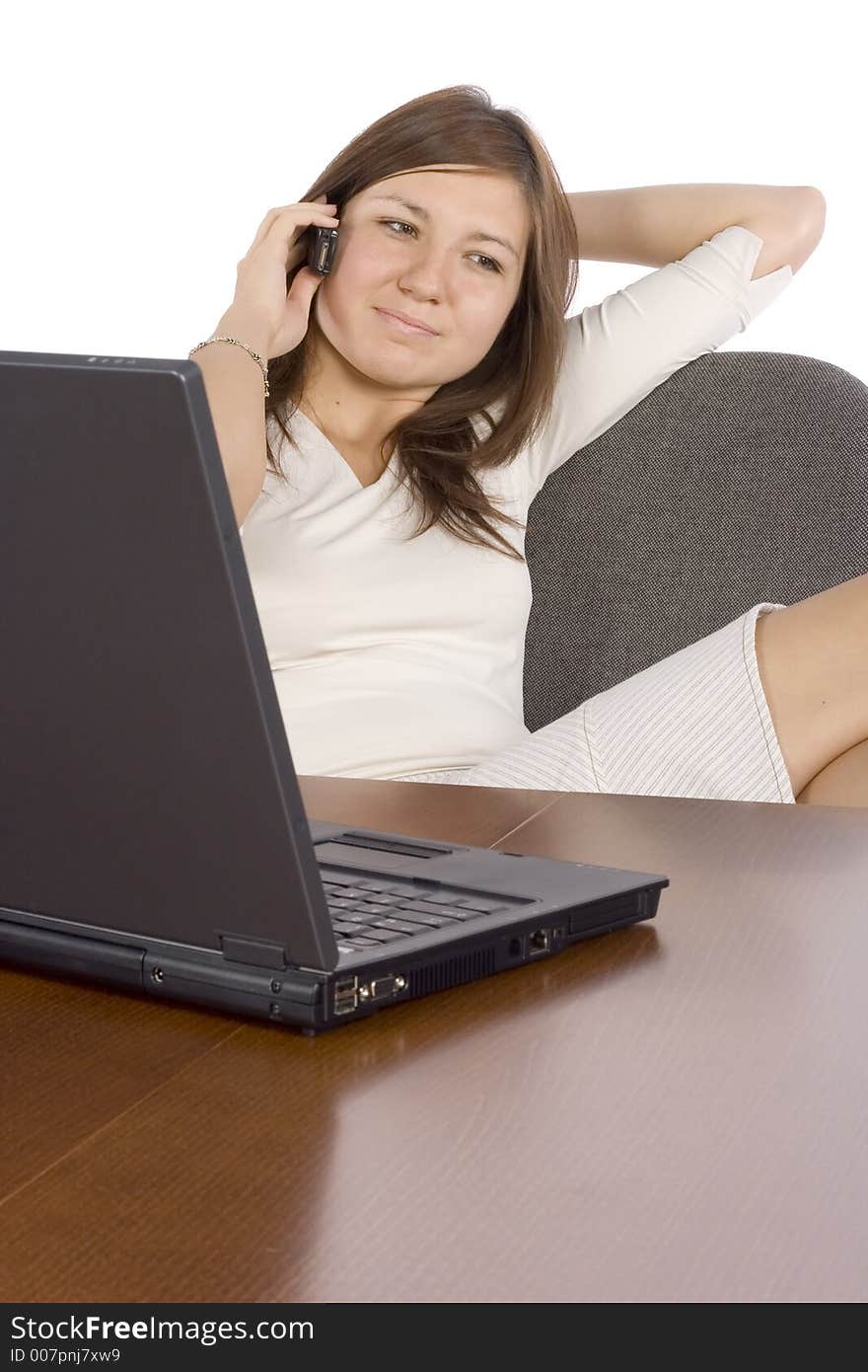 Woman at the desk talking by mobile phone