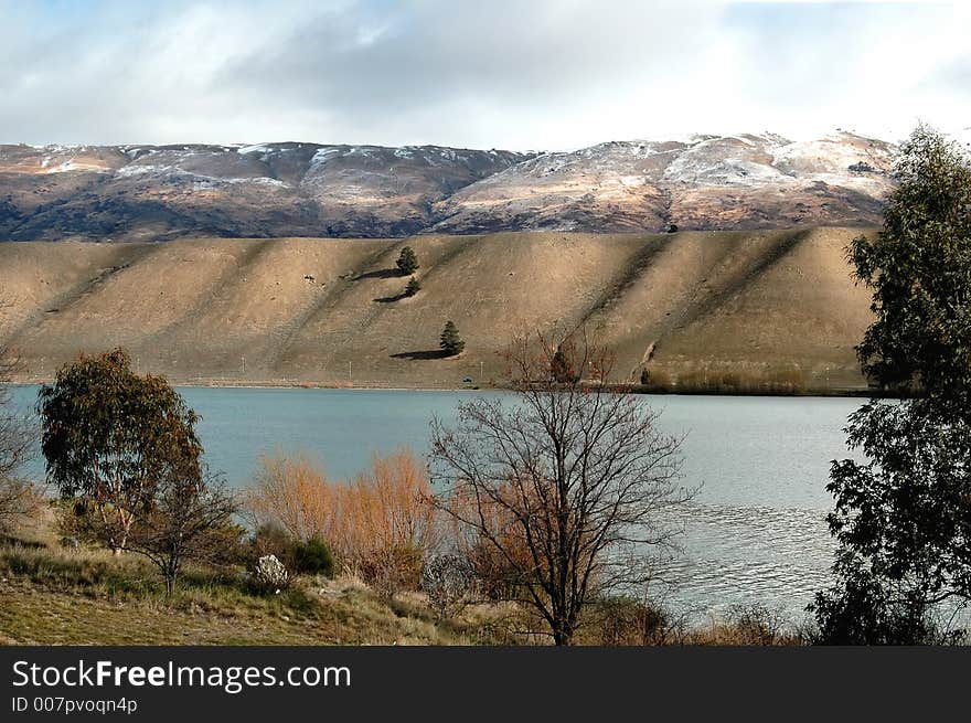 Undulating river bank with ice cover mountain in background. Undulating river bank with ice cover mountain in background