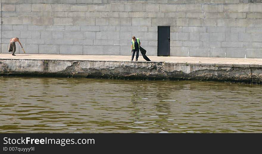 Janitors  clean dust on quay