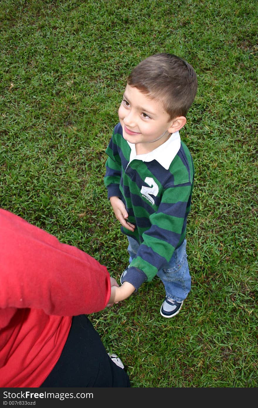 Kid listening to daddy in a soccer field. Kid listening to daddy in a soccer field