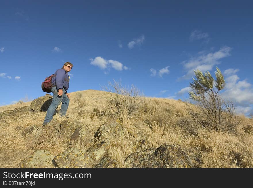 One adult with backpack climbing mountain,. One adult with backpack climbing mountain,