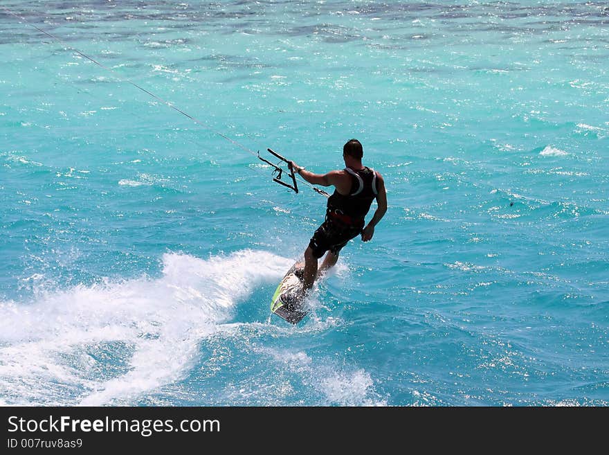 Kitesurfer downwind on a colorful lagoon