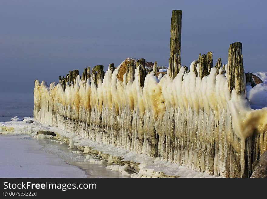 Ice-covered breakwater and icicles like line of white bearded gnomes