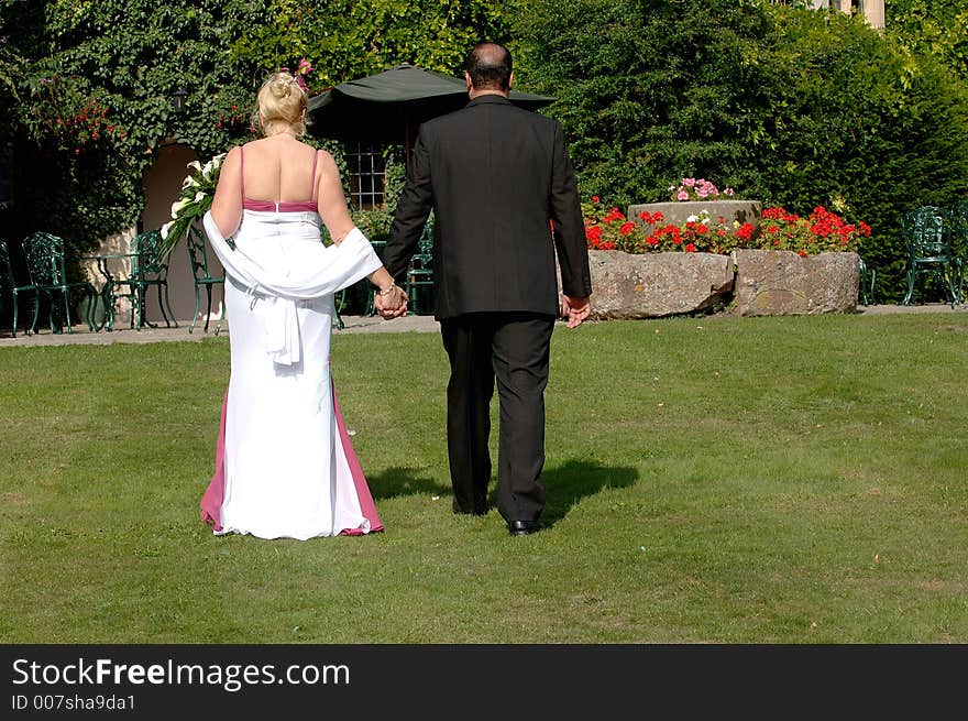 Bride and groom walking in gardens. Bride and groom walking in gardens