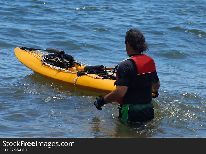 A man is ready to jump into the kayaki. A man is ready to jump into the kayaki