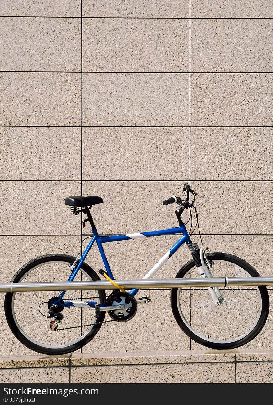 One bike on the parking with marble wall. One bike on the parking with marble wall