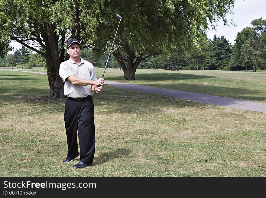 Man studies the lie of his last golf drive. Man studies the lie of his last golf drive.