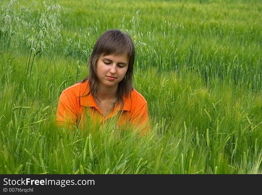 Orange girl looking at wheat field