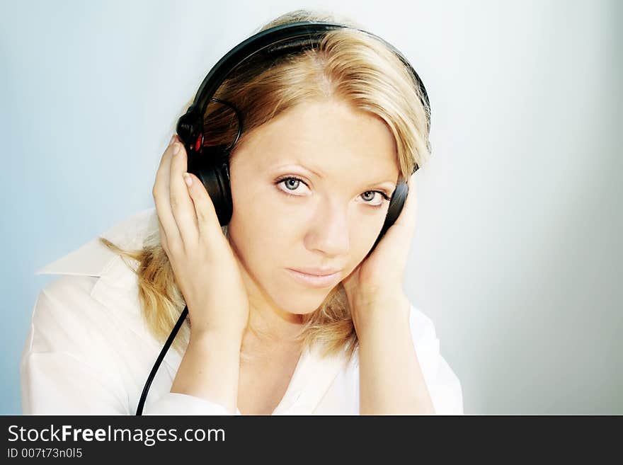 A young, blond woman is listening music