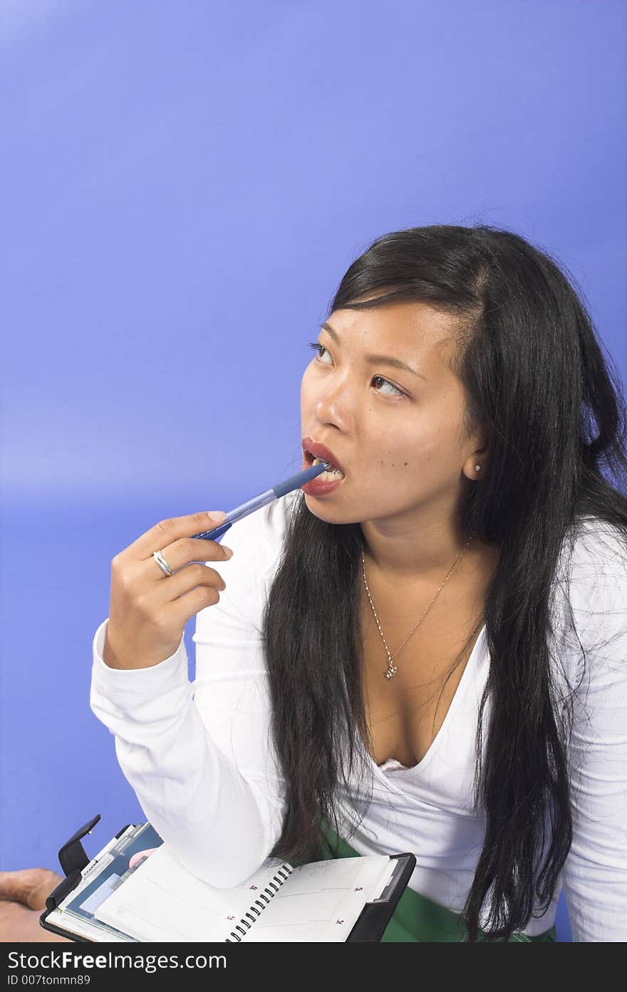 Girl thinking with pen on mouth