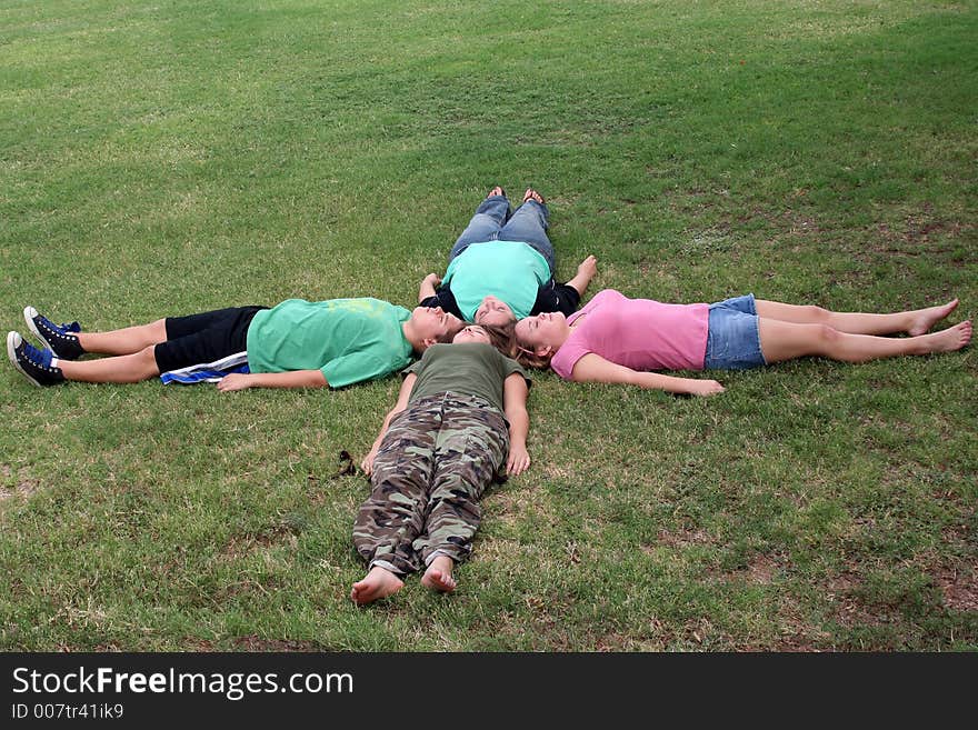 Four teenagers with their heads touching, making an x. Four teenagers with their heads touching, making an x.