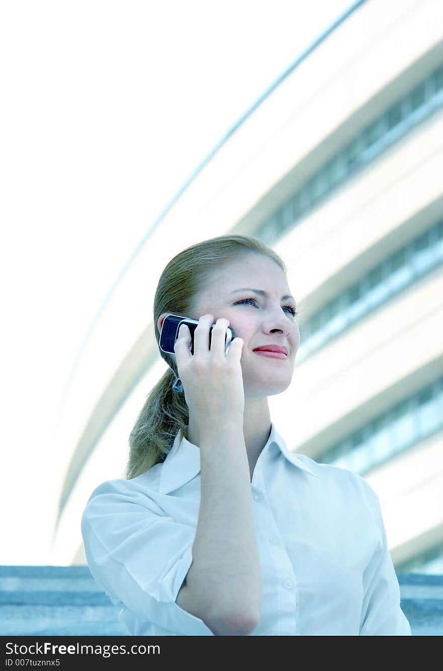 Bussines woman in front of corporate building, on a cellphone conversation. Bussines woman in front of corporate building, on a cellphone conversation