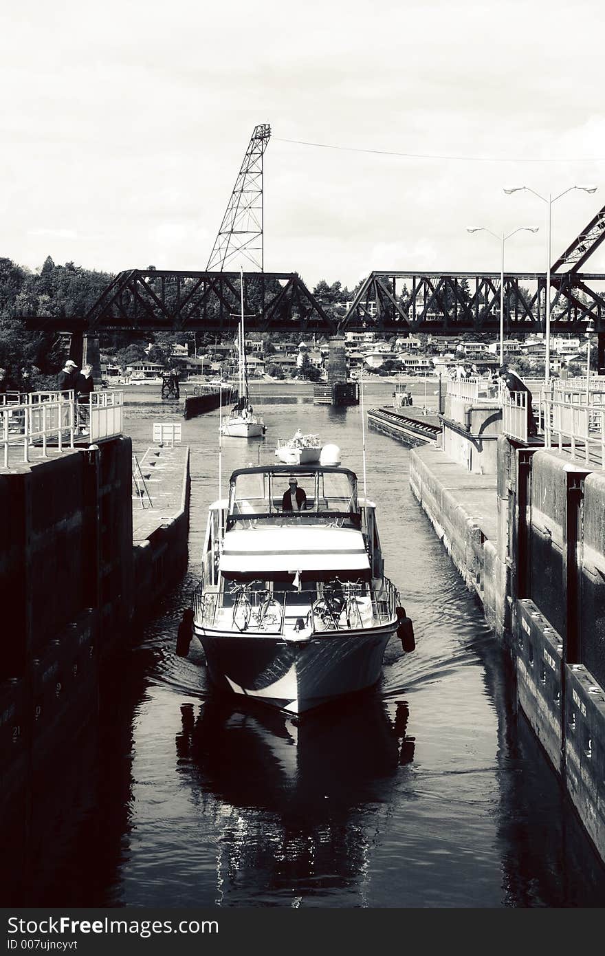 Black and white view of cabin cruiser boat in dock with industrial crane in background. Black and white view of cabin cruiser boat in dock with industrial crane in background.