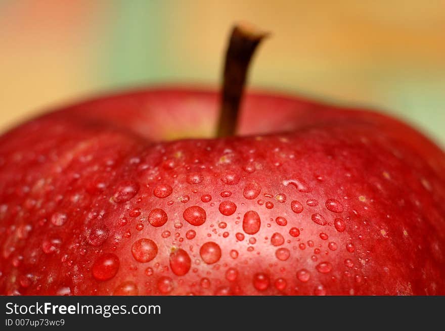 An apple covered with water droplets. An apple covered with water droplets.