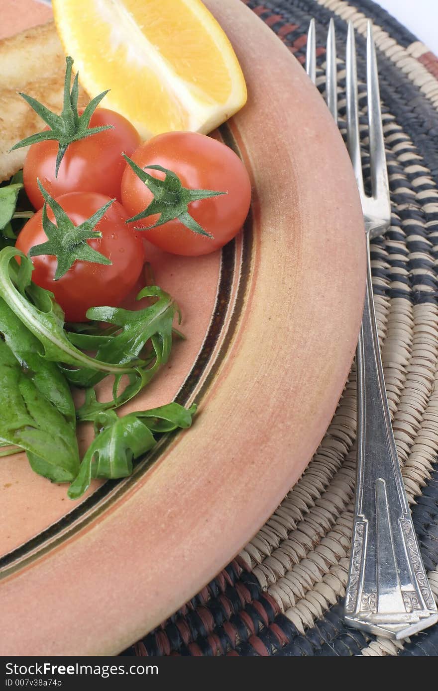 Stoneware plate and salad on African mat