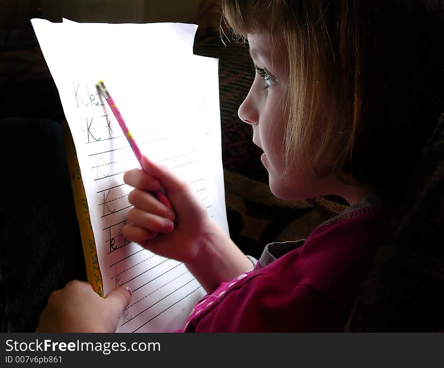 Little Girl Doing Homework with Pencil and Paper