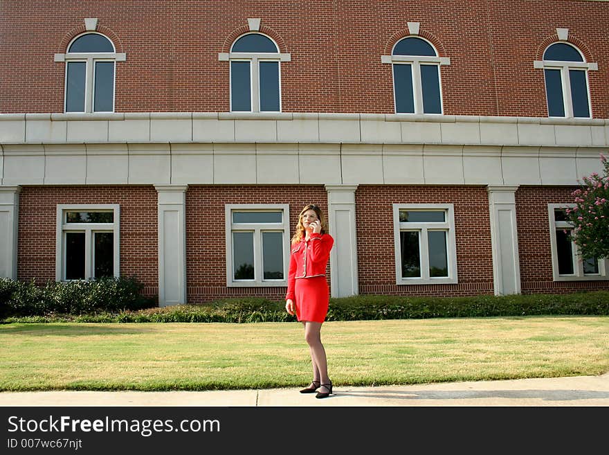 Businesswoman on cell phone; brick building background. Businesswoman on cell phone; brick building background