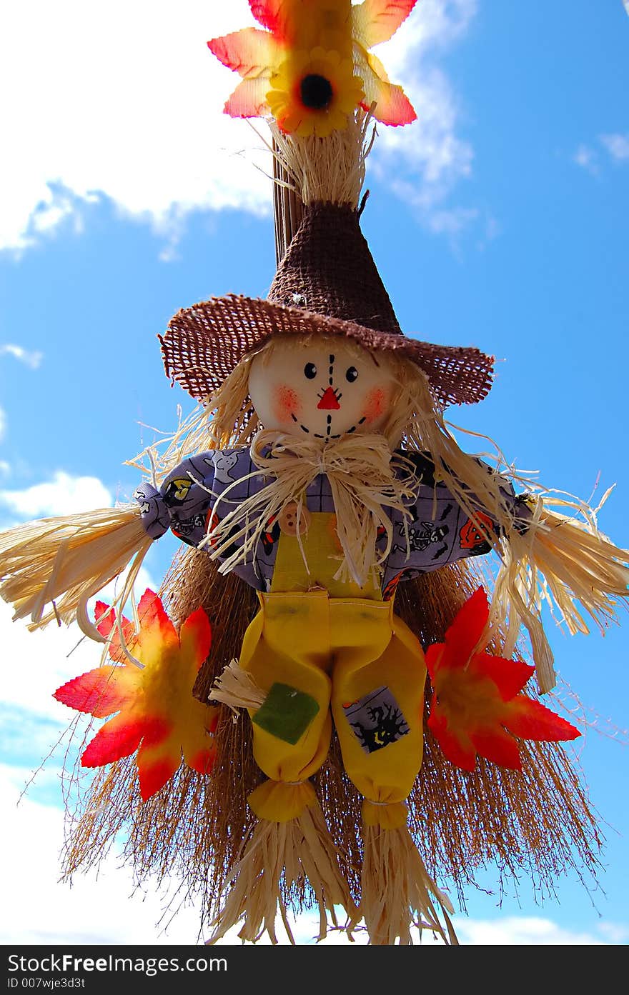 Little cute scarecrow with sky as background