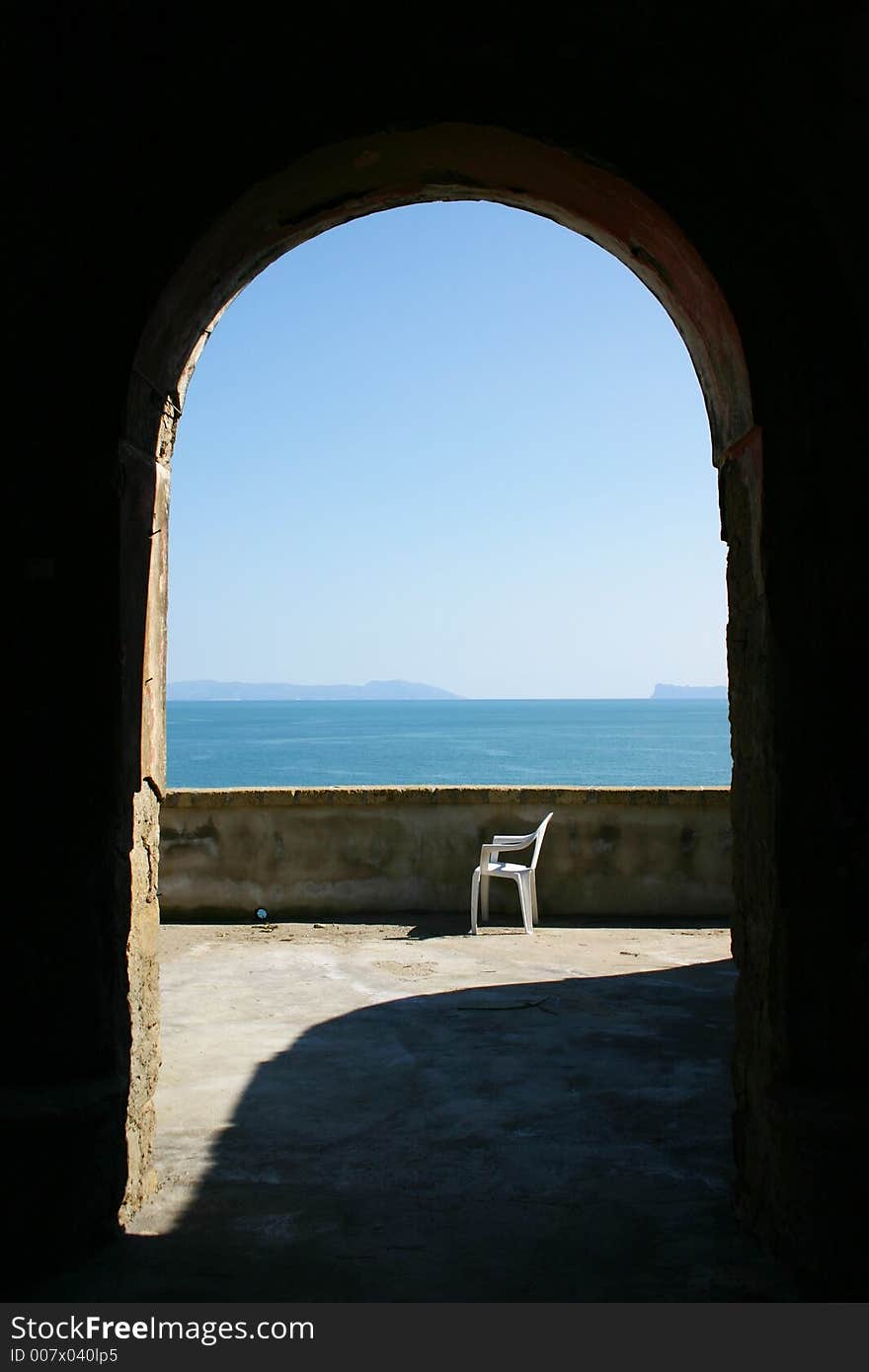 A chair on seashore in arch frame. A chair on seashore in arch frame.