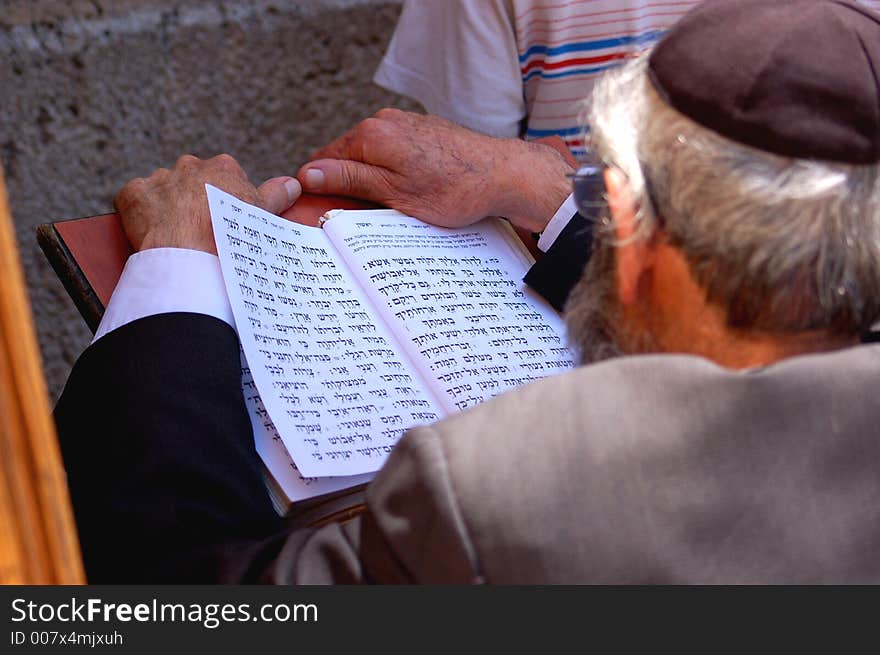 An older man praying open book