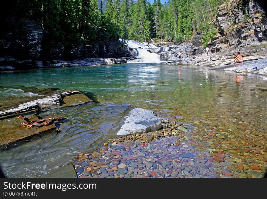 Sunbathers and swimmer enjoy MacDonald Falls and Creek. Sunbathers and swimmer enjoy MacDonald Falls and Creek