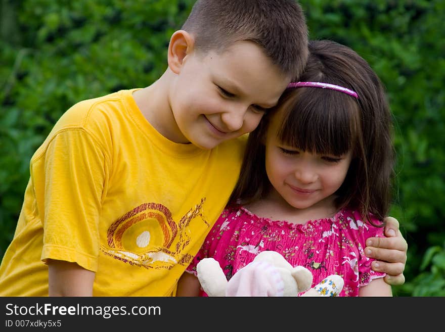 Sister with brother looking at a doll. Sister with brother looking at a doll