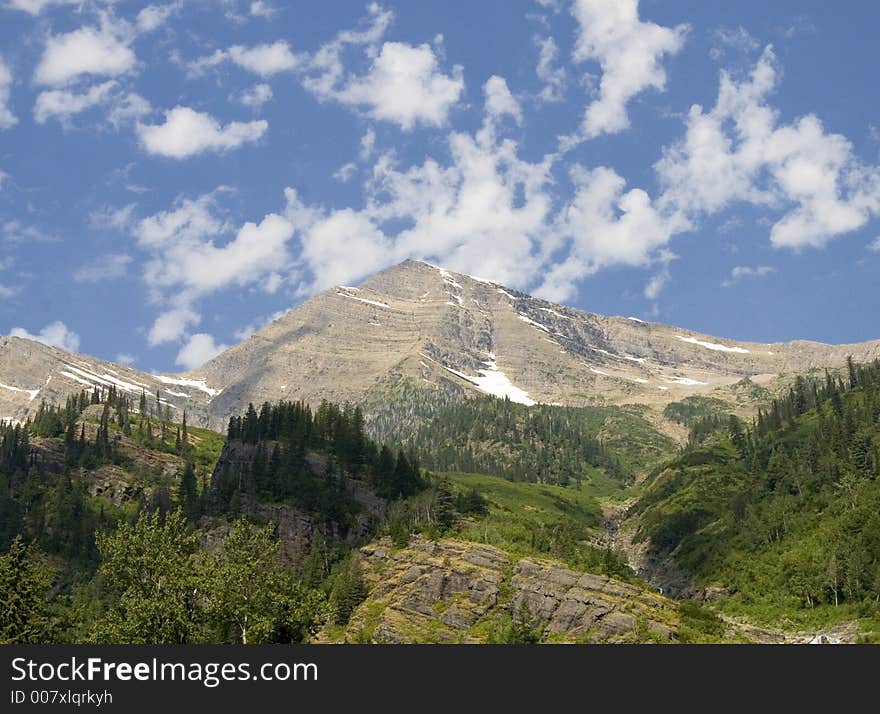 A huge mountain in Glacier National Park, captured with a beautiful blue sky above it. A huge mountain in Glacier National Park, captured with a beautiful blue sky above it.